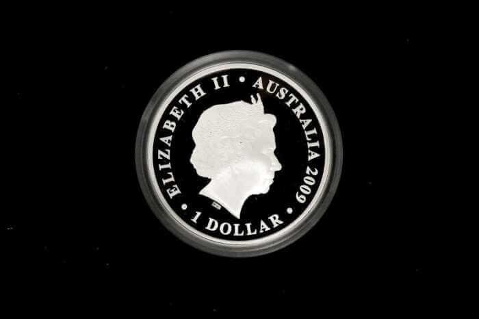 A circular silver coin featuring the profile of Queen Elizabeth II with the text 'ELIZABETH II • AUSTRALIA 2009 • 1 DOLLAR' around the edge, shown against a solid black background.