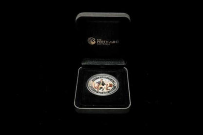 A Perth Mint Australia commemorative coin presented in an open black gift box on a black background. The circular silver-toned coin features a central figure and is displayed inside a black velvet-lined box with the Perth Mint logo visible on the inside lid.
