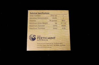 A square wooden card with engraved technical specifications and branding for The Perth Mint Australia, photographed against a solid black background.