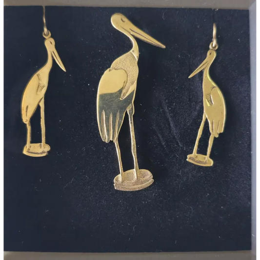 Gold bird-shaped earrings on a dark blue card