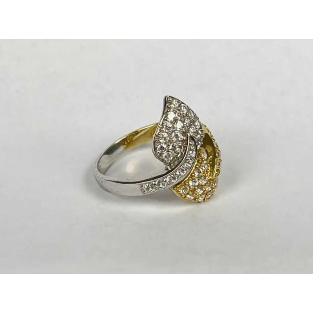 Two-tone ring with diamond accents on a light gray background