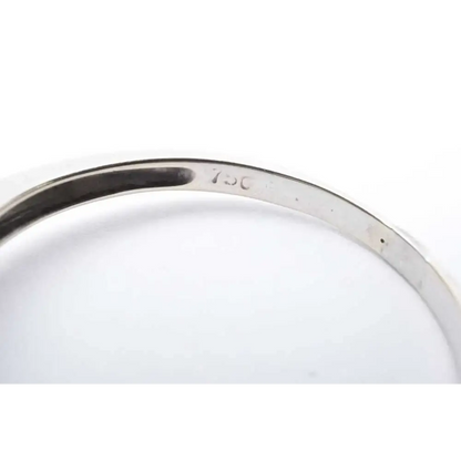 Close-up of a silver ring with '925' stamp on a white background
