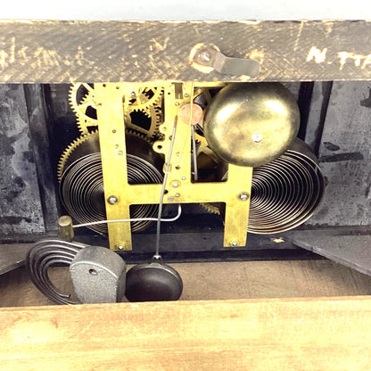 Close-up of a clock mechanism with gears and a pendulum inside