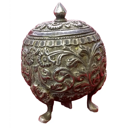Decorative metal container with intricate designs on a white background