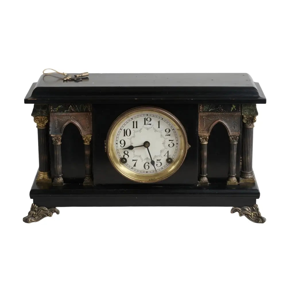 Decorative clock with black and gold design on a white background