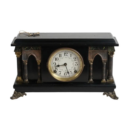 Decorative clock with black and gold design on a white background