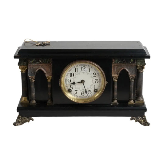 Decorative clock with black and gold design on a white background