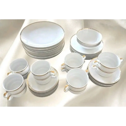 Set of white ceramic dinnerware with gold trim 