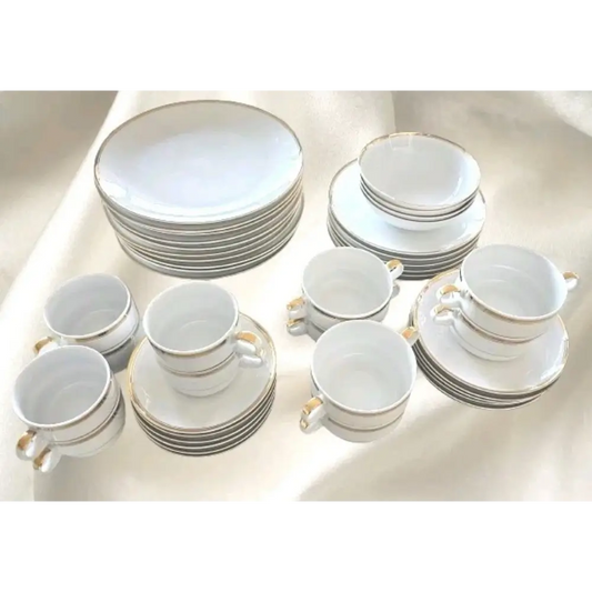 Set of white ceramic dinnerware with gold trim 