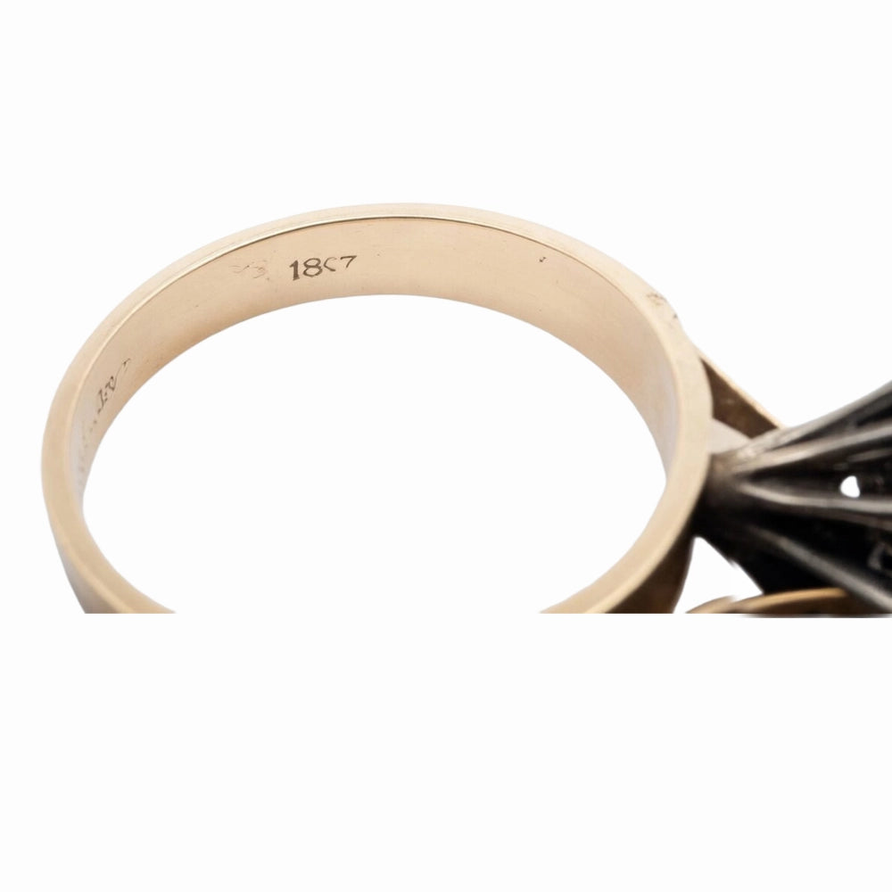 Close-up of a gold ring with '18k' marking on a white background