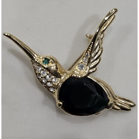 Gold hummingbird brooch with black body and gemstones