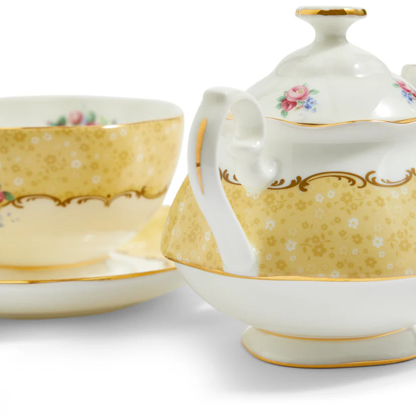 Porcelain teapot and cup with floral patterns on a white background