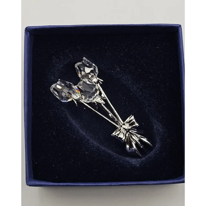 Silver rose brooch on a dark blue velvet background