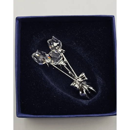 Silver rose brooch on a dark blue velvet background