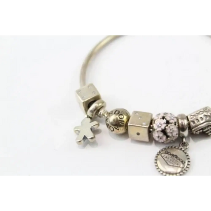 Silver charm bracelet with various charms on a white background