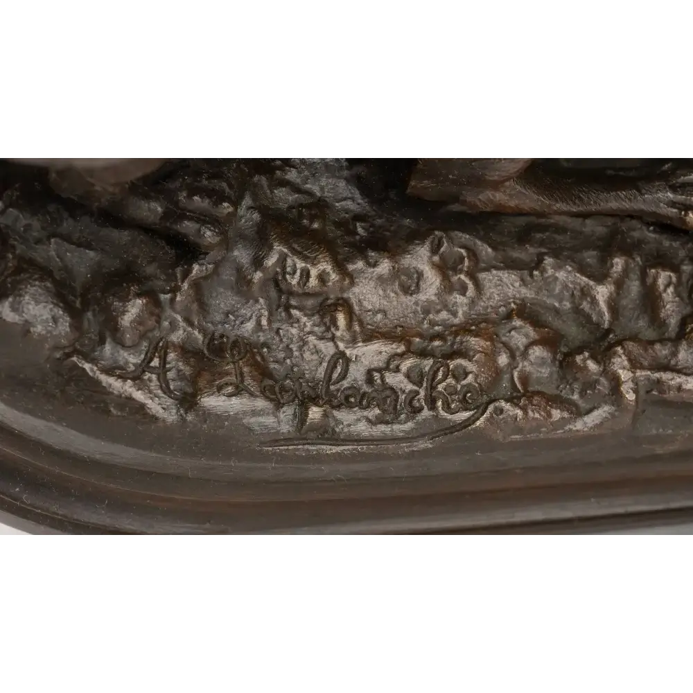 Close-up of a bronze sculpture with engraved text on a white background