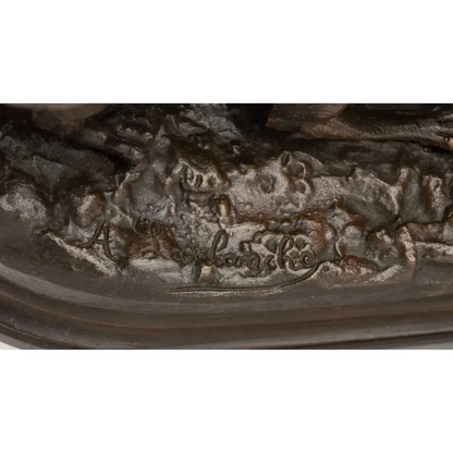 Close-up of a bronze sculpture with engraved text on a white background