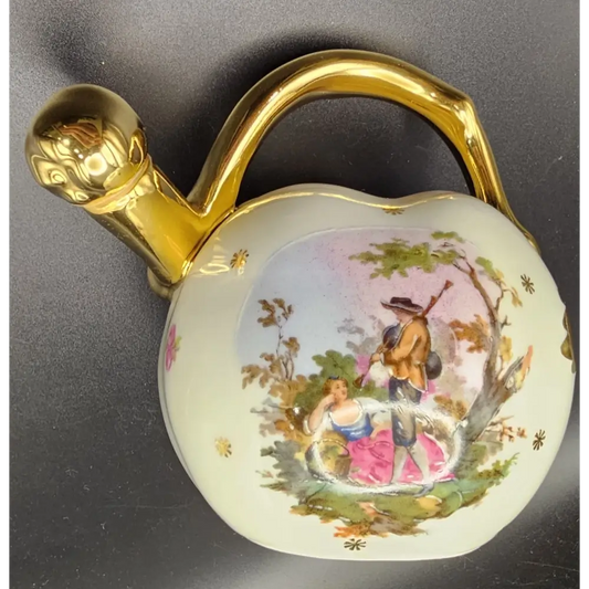 Decorative ceramic object with gold handle and painted scene