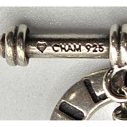Close-up of a silver charm with 'Gian' and '925' stamp on a white background