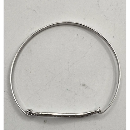 Silver bangle on a light gray background