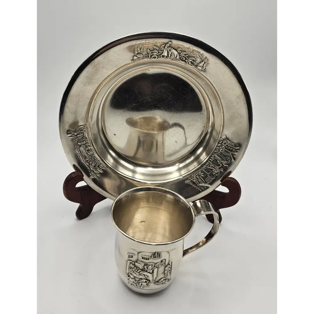 Silver cup and tray with engraved designs on a white background