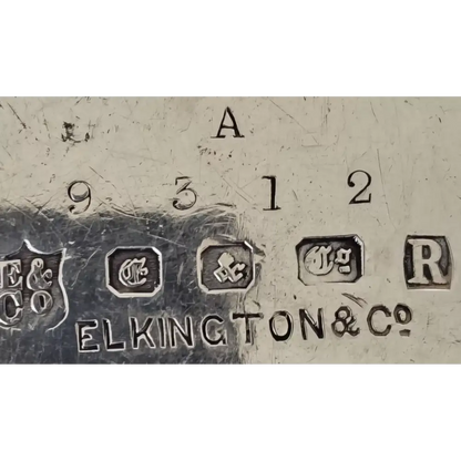 Close-up of metal surface with 'Elkington & Co' branding and numbers.