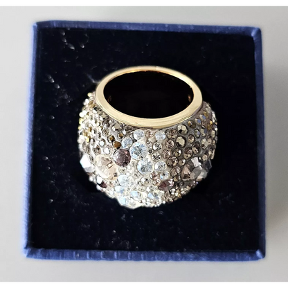 Gold ring with crystal embellishments on a black cushion