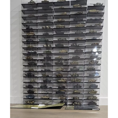 Collection of model tanks in clear display cases against a white wall.
