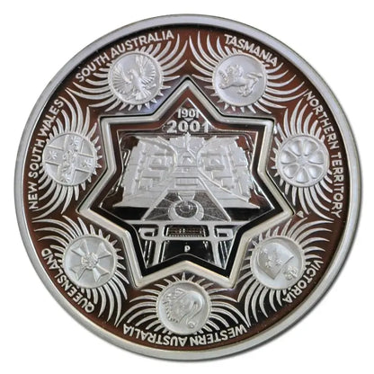 A circular commemorative coin featuring a silver-toned central star and train motif, surrounded by raised silver states and engraved text naming Australian regions including South Australia, Tasmania, Northern Territory, Queensland, Western Australia, Victoria, New South Wales, and South Australia. The outer ring is dark brown with silver detailing.