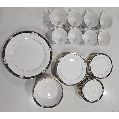 Set of ceramic dinnerware with decorative rim on a white surface