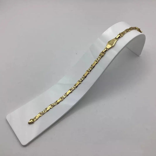 Gold chain bracelet on a white stand