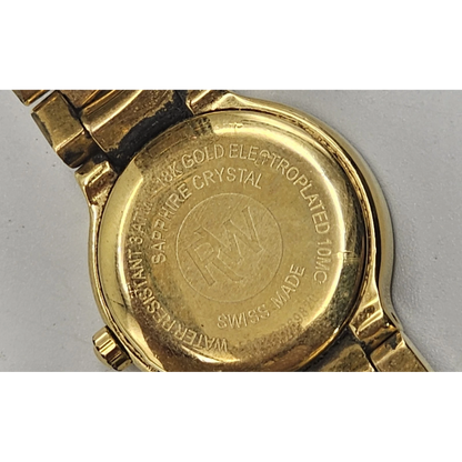 Gold watch case with brand engraving on a gray background