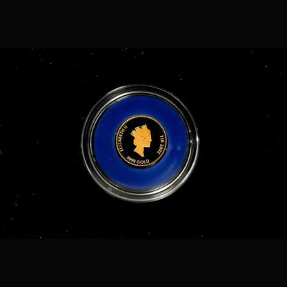 A round collectible coin in a clear protective capsule, featuring a vibrant blue background with a gold-colored British Gold Medal profile of Queen Elizabeth II and the text 'BRITISH GOLD MEDAL 1818-2022'.