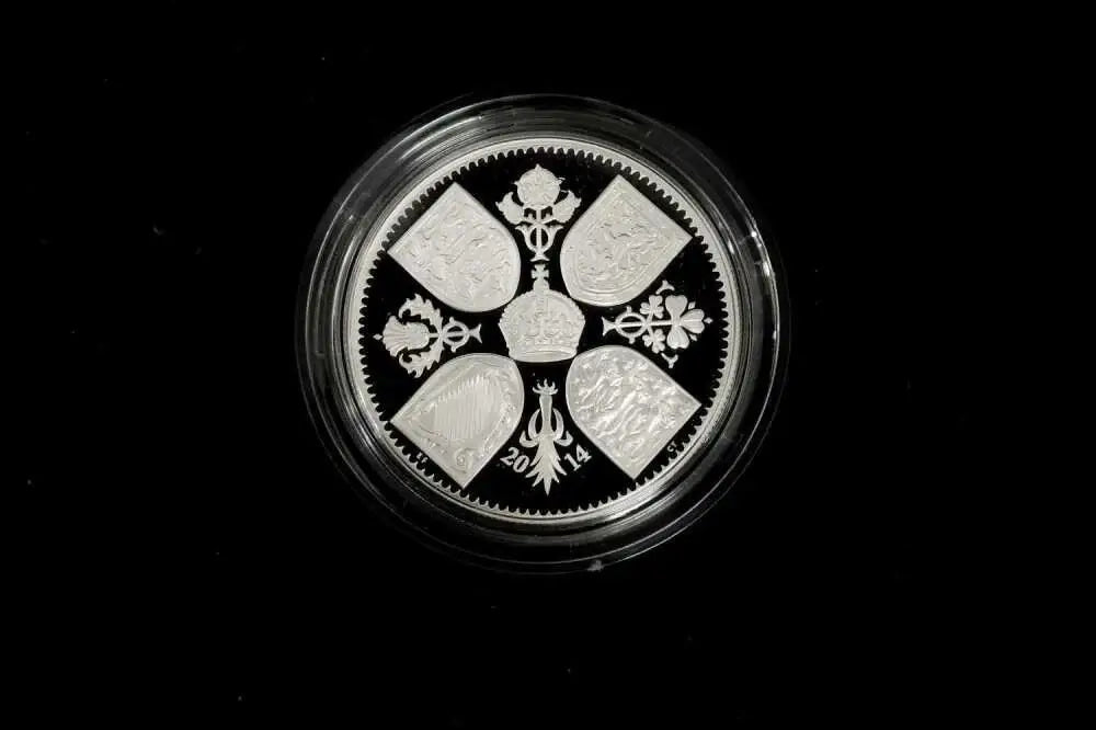 A round silver coin with a detailed traditional design, encased in a clear protective plastic capsule, set against a solid black background.