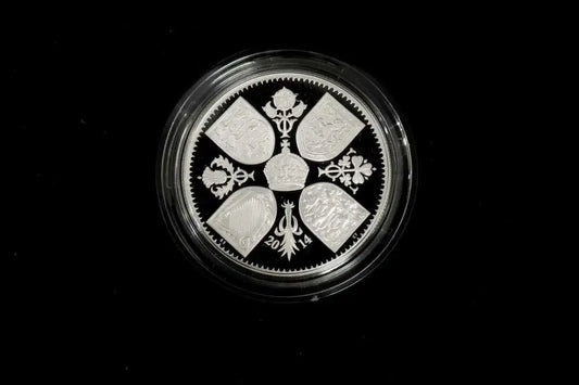 A round silver coin with a detailed traditional design, encased in a clear protective plastic capsule, set against a solid black background.