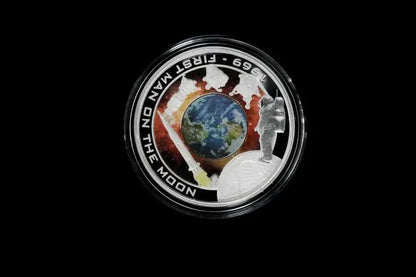 A circular commemorative coin or medallion featuring a silver-toned border with the text '1969 - FIRST MAN ON THE MOON' and 'JEEP 699', surrounding an Earth globe and space-themed illustration, shown on a black background.