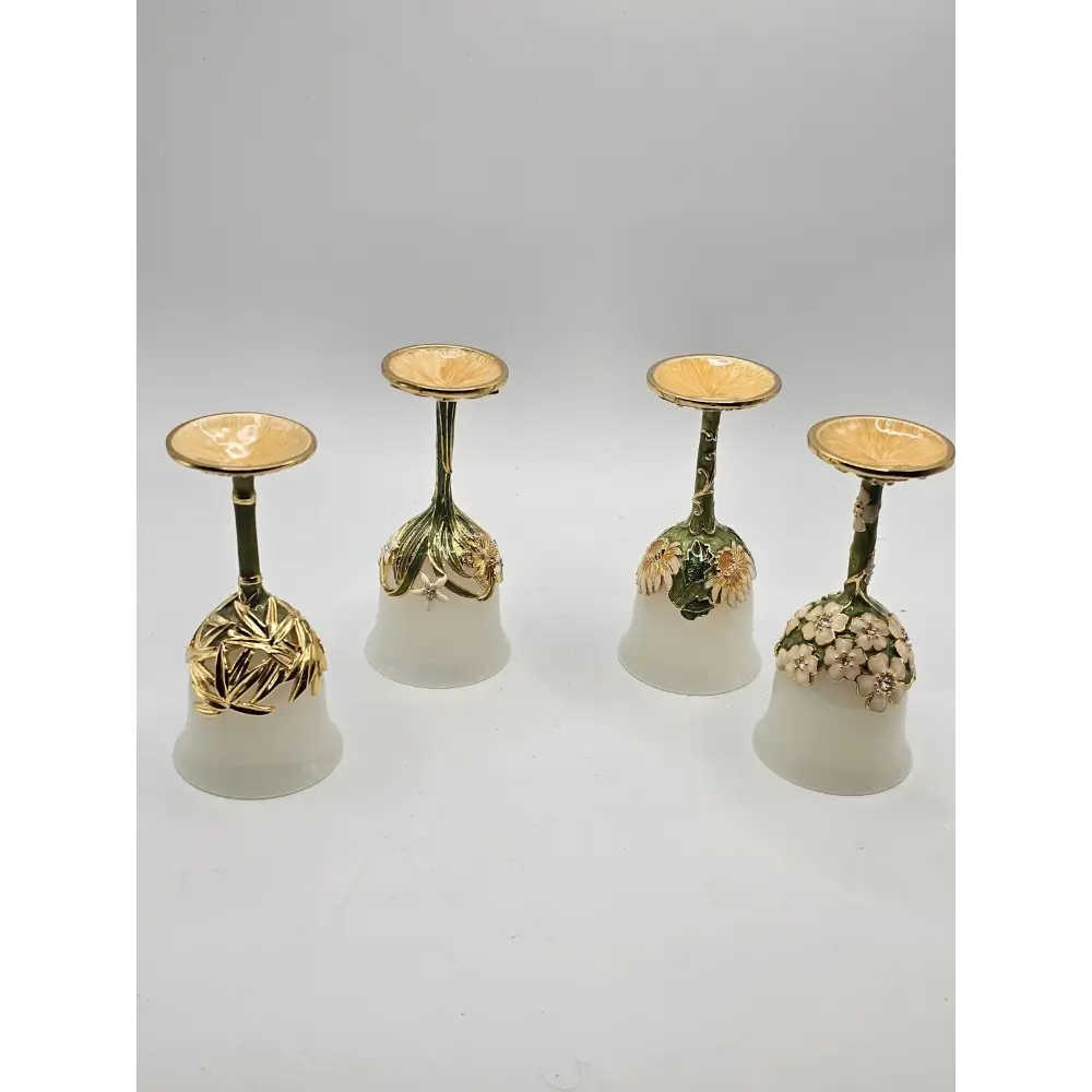 Set of four decorative  glasses with gold bases on a light gray background