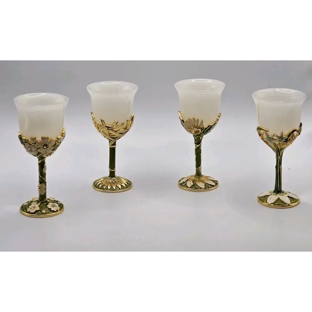 Four ornate gold and white goblets on a gray background