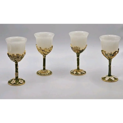 Four ornate gold and white goblets on a gray background