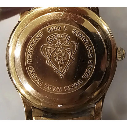 Gold Gucci watch case with brand logo 