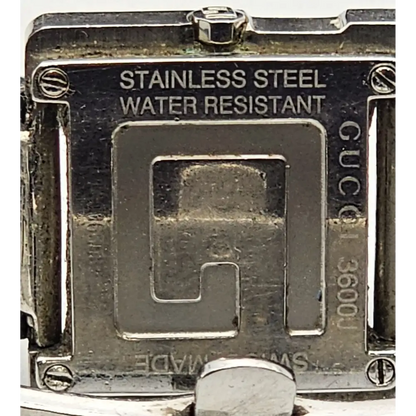 Close-up of a Gucci watch case with 'Stainless Steel' and 'Water Resistant' text.