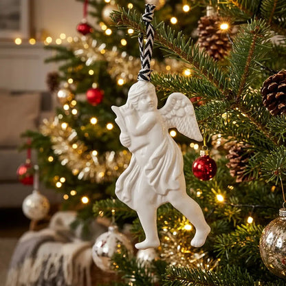 White angel ornament on a decorated Christmas tree with lights and ornaments.