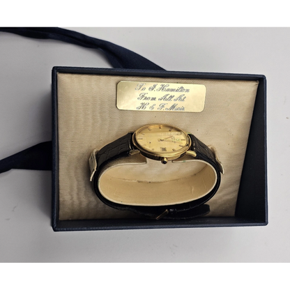 Gold watch in a box with a label