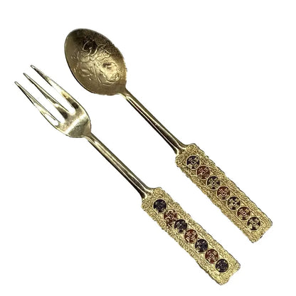 Gold fork and spoon set with decorative handles on a white background
