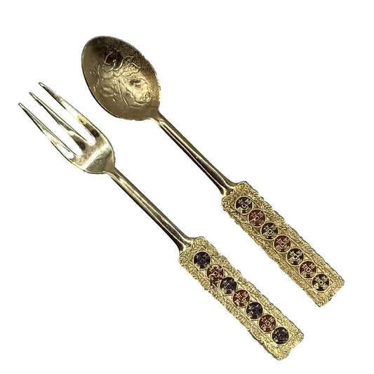 Gold fork and spoon set with decorative handles on a white background
