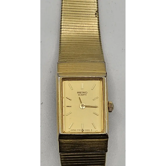Gold Seiko watch on a gray background