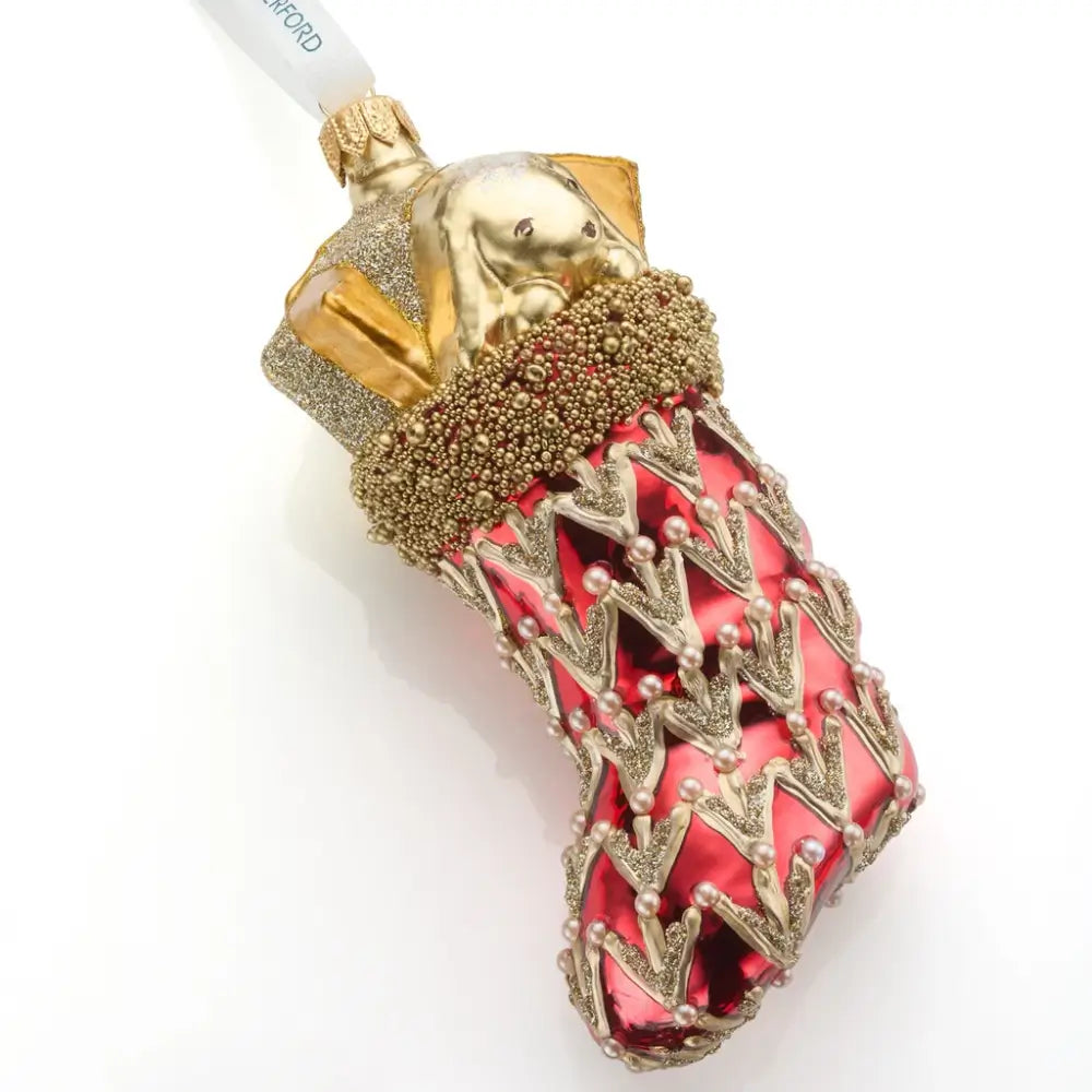 Decorative red stocking ornament with gold and red design on a white background