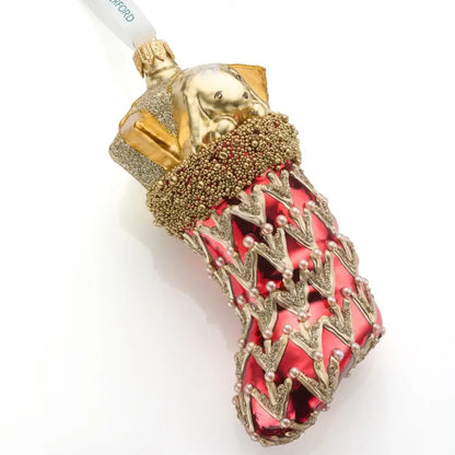 Decorative red stocking ornament with gold and red design on a white background