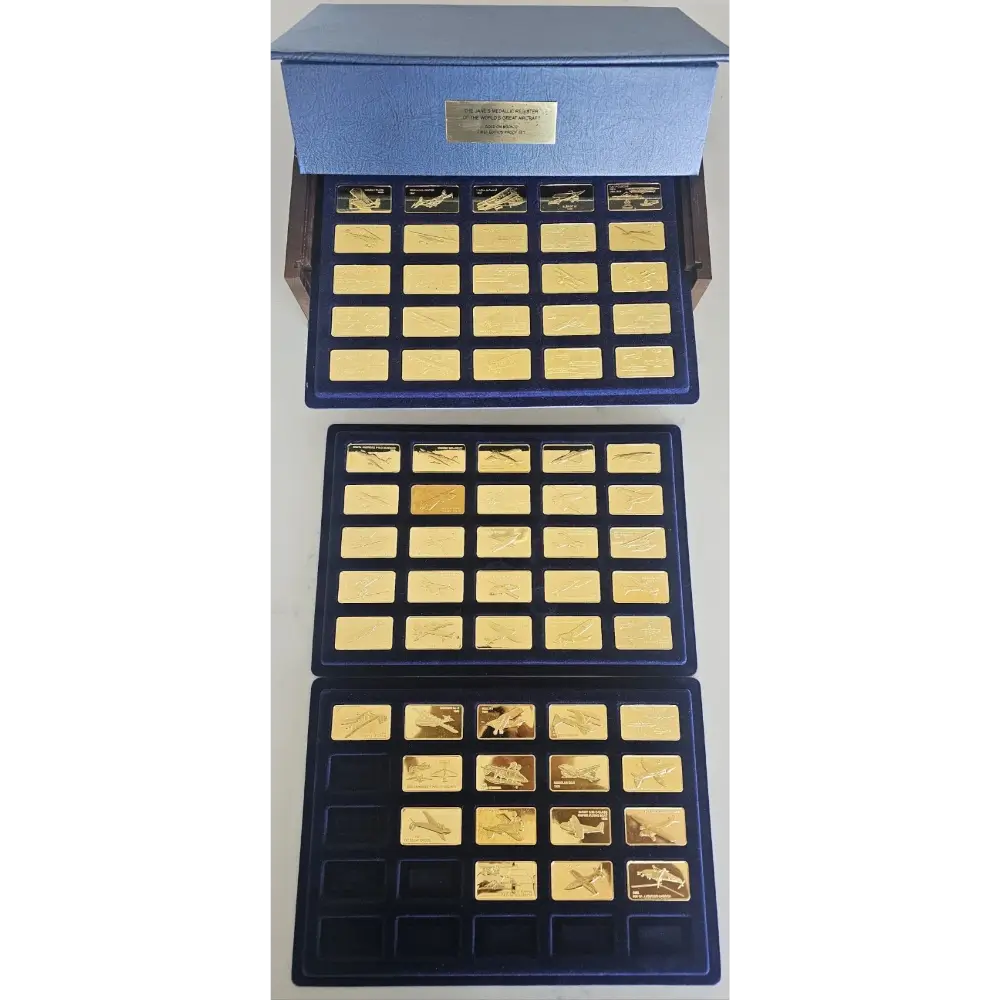 Collection of gold bars in a blue display case on a white background