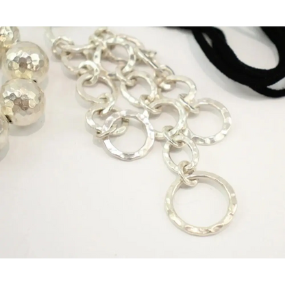 Close-up of a silver chain necklace on a white background